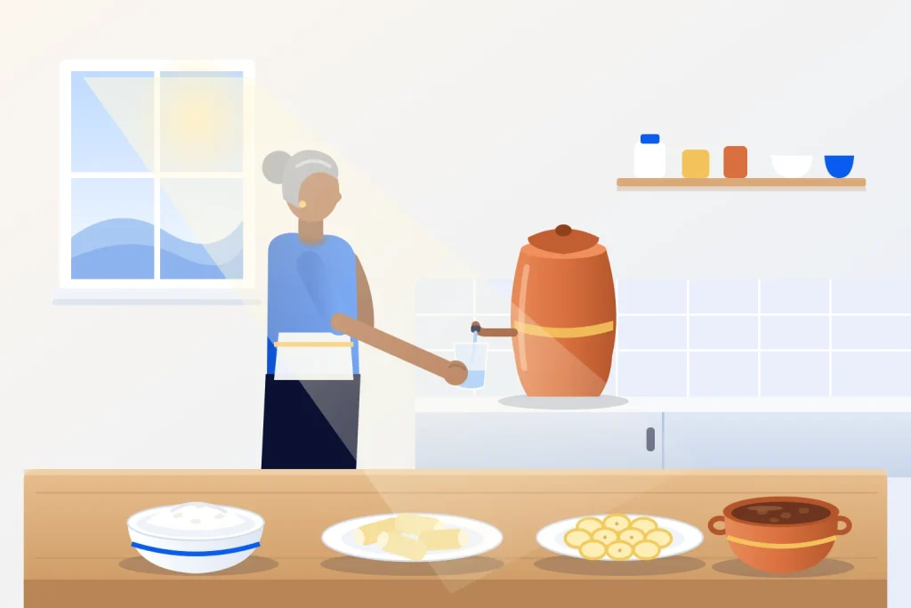 Mulher serve um copo de água na cozinha de casa, ao lado de arroz, macaxeira cozida, banana e caldo de feijão na mesa.